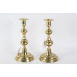 A pair of 19th century brass candlesticks, with a knopped stem above a circular foot, 24cm high