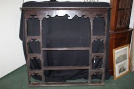 An oak plate rack, 18th Century elements, the concave cornice above an undulating apron and a series