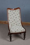 A Victorian mahogany nursing chair, with a floral upholstered back and seat raised on tulip style