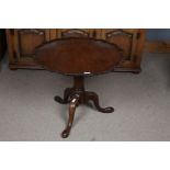 A George III mahogany occasional table, with a pie crust top above a turned pillar on tripod legs