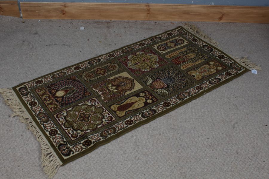 A unusual Keshan rug, the olive green ground set with various panels depicting various designs