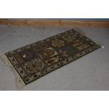 A unusual Keshan rug, the olive green ground set with various panels depicting various designs