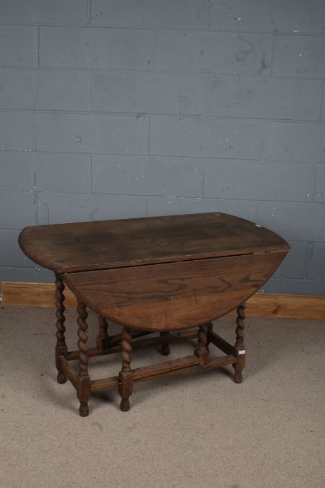 A 20th century oak gate leg drop leaf table, the circular top above barley twist legs, 115cm wide