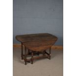 A 20th century oak gate leg drop leaf table, the circular top above barley twist legs, 115cm wide