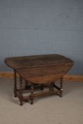 A 20th century oak gate leg drop leaf table, the circular top above barley twist legs, 115cm wide