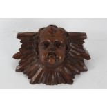 A 17th century style wall bracket, decorated with a cherubs head, 32cm wide 19cm high