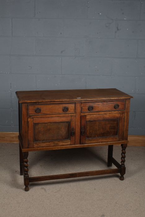 A 20th century oak cupboard, the rectangular top above two drawers and two cupboard doors opening to