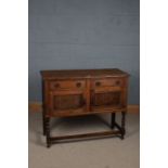 A 20th century oak cupboard, the rectangular top above two drawers and two cupboard doors opening to