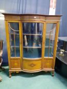 A Edwardian mahogany inlaid display cabinet having a bowfronted center section with glazed doors