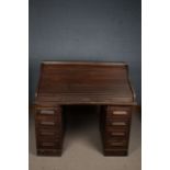A 20th century oak tambour roll top desk, the desk opening to reveal an assortment of drawers and
