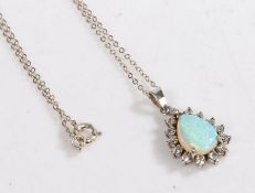 A silver opal and paste pendant and necklace, the pendant set with a pear shaped opal surrounded