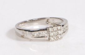 A 9 carat white gold and diamond ring, the head set with nine diamonds and three to either shoulder,