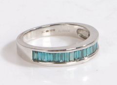 A 9 carat white gold and aquamarine ring, set with a row of baguette cut aquamarines, ring size O