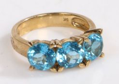 A 9 carat gold ring, the head set with three claw mounted brilliant cut vibrant blue stones, ring