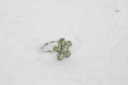 A 9 carat white gold, diamond and green sapphire ring, the head in the form of a flower set with