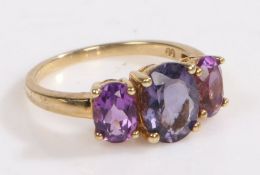 A 9 carat gold ring, the head set with three claw mounted oval purple glass stones, ring size O