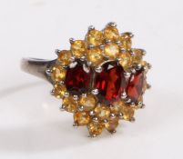 A Silver, garnet and citrine cluster ring, the head set with three claw mounted oval garnets