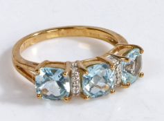 A 9 carat gold, diamond and aquamarine ring, the head set with three cushion cut claw mounted