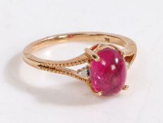 A 9 carat gold, diamond and rubellite ring, the head set with a claw mounted cabochon cut