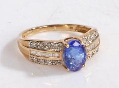 A 9 carat gold, diamonds and tanzanite ring, the head set with a claw mounted oval tanzanite stone