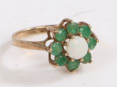 A 9 carat gold, white opal and green stone ring, the head of floral form set with a central cabochon