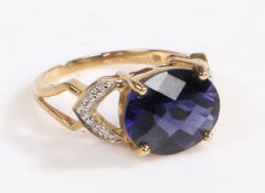 A 9 carat gold, diamond and ceylon iolite ring, the head set with a claw mounted oval ceylon