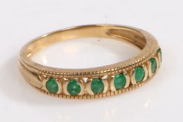 A 9 carat gold ring, the head set with a row of green stones, ring size P 1/2 weight 2.4 grams