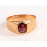 A yellow metal and garnet ring, the head set with a single oval garnet, ring size P weight 2.7 grams