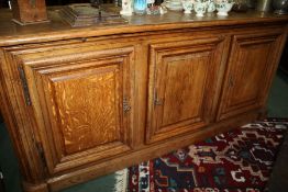 Large 20th century oak sideboard, the round cornered top above three doors enclosing a shelf,