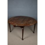 A 19th century oak drop leaf table, the top with two semi circular drop leaves above tapering legs