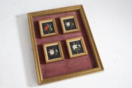 Four small pietra dura panels depicting flowers, housed in gilt frames and all presented in a beaded