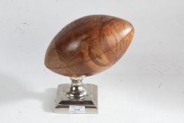 Ornamental wooden rugby ball, raised on square chromed base, 21cm high