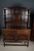 20th century oak dresser and rack, the base fitted two short drawers with cupboards below, raised on