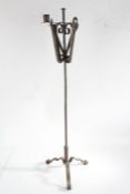 Iron companion stand, the scrolled basket top with candle sconce, pricket, hook and scroll, on a