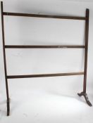 Early 20th century stained beech towel rail, with three horizontal bars, raised on scroll feet. 89cm
