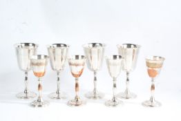 Two sets of four silver plated metal goblets, both with floral decoration, the largest 18cm high, (