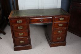 A 20th century mahogany leather topped desk, with a green leather and gilt tooled top above nine