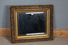 Ornate gilt framed wall mirror, centred with a bevelled glass plate within a scrolling border,