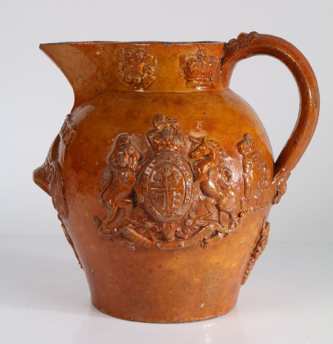 19th Century pottery Patent jug, the honey glaze with crowns and flowers to the rim above the