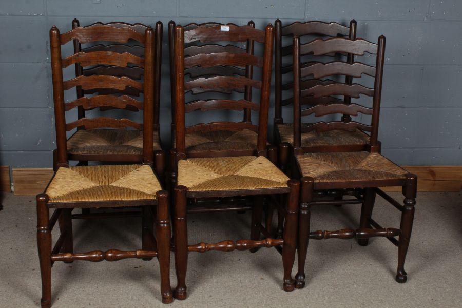 Six oak ladder back dining chairs, all with rush seats, largest 100cm high