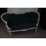 A 20th century French white painted settee/sofa, having a floral carved back rail above a light blue