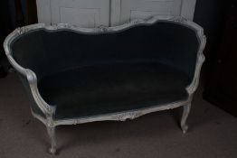 A 20th century French white painted settee/sofa, having a floral carved back rail above a light blue