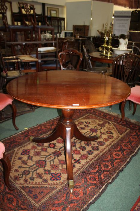 A Victorian mahogany tilt top breakfast table, the circular top above a turned baluster column