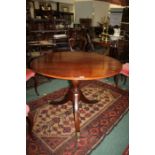 A Victorian mahogany tilt top breakfast table, the circular top above a turned baluster column