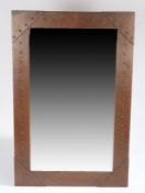 Arts & Crafts copper framed wall mirror, the frame with beaten and riveted decoration, 48cm x 75cm