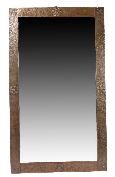 Arts & Crafts copper framed mirror, the beaten frame with fleur de lys and rose decoration