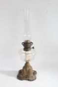Art Nouveau cast metal based oil lamp, the glass chimney above a clear glass reservoir, raised on