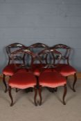 Five 20th century mahogany dinging chairs, with floral decorated backs above red upholstered
