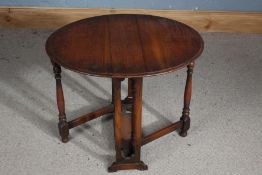 Small oak Sutherland table, with two oval drop leaves, raised on turned and flattened legs and