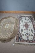 Two 20th century Indian rugs, both with light colourings, one with rounded ends, the largest 184cm